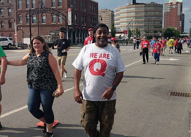 A man wears a QAnon shirt.